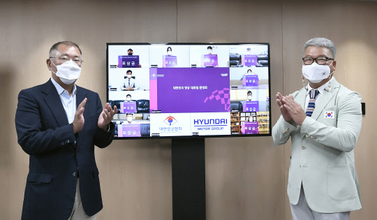 정의선(왼쪽) 현대자동차그룹 회장(양궁협회장)이 온택트 방식으로 진행된 '2020 도쿄대회 대한민국 양궁 대표팀 환영회' 행사에서 박채순 양궁 국가대표팀 총감독 및 선수단과 함께 기념 촬영하고 있다. 대한양궁협회 제공